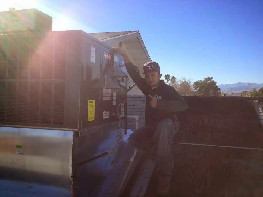 HVAC technician performing AC Tune-Up on a rooftop unit in Winthrop Town